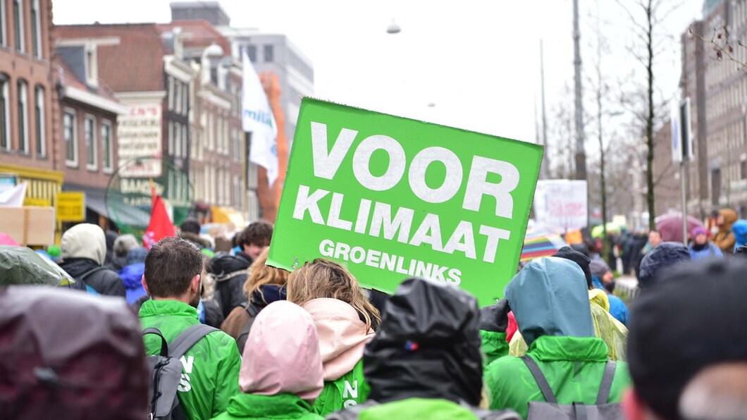 Foto van een klimaatmars met een GroenLinks bord waarop staat: Voor Klimaat, GroenLinks