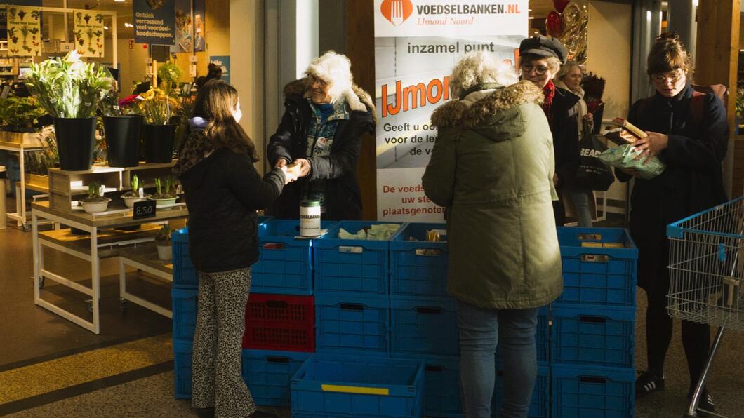 Drie mensen doneren levensmiddelen aan de Voedselbank bij een inzamelingsactie in Geesterduin