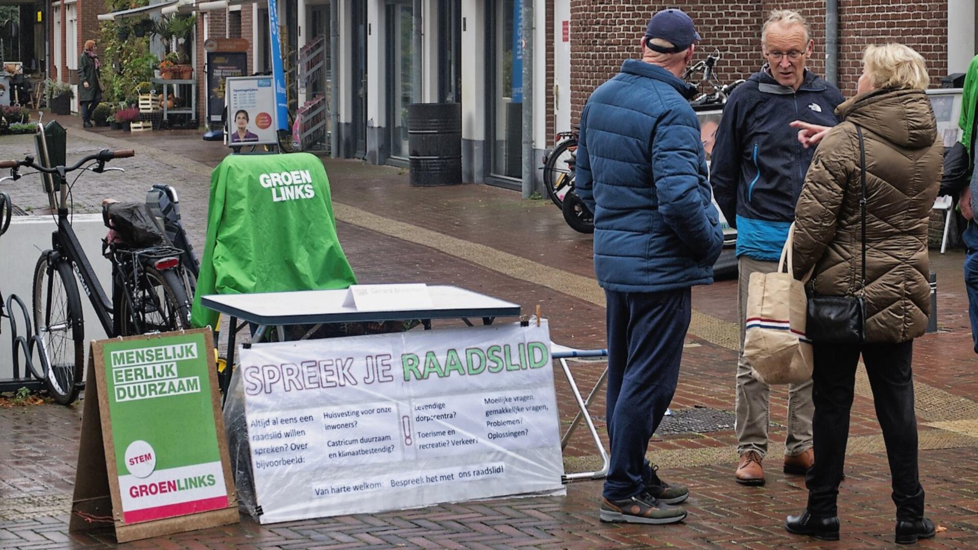 Foto van Gerard Brinkman in gesprek met twee mensen op de markt
