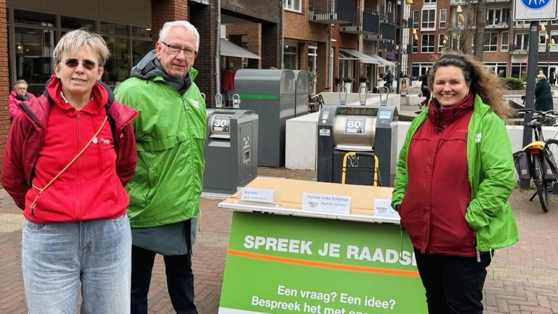 Foto van PvdA-raadslid José Smits, GroenLinks commissielid Frits Puhl en GroenLinks raadslid Hannie Lutke Schipholt tijdens het politieke spreekuur op de markt: Spreek je GroenLinks- en PvdA-raadslid