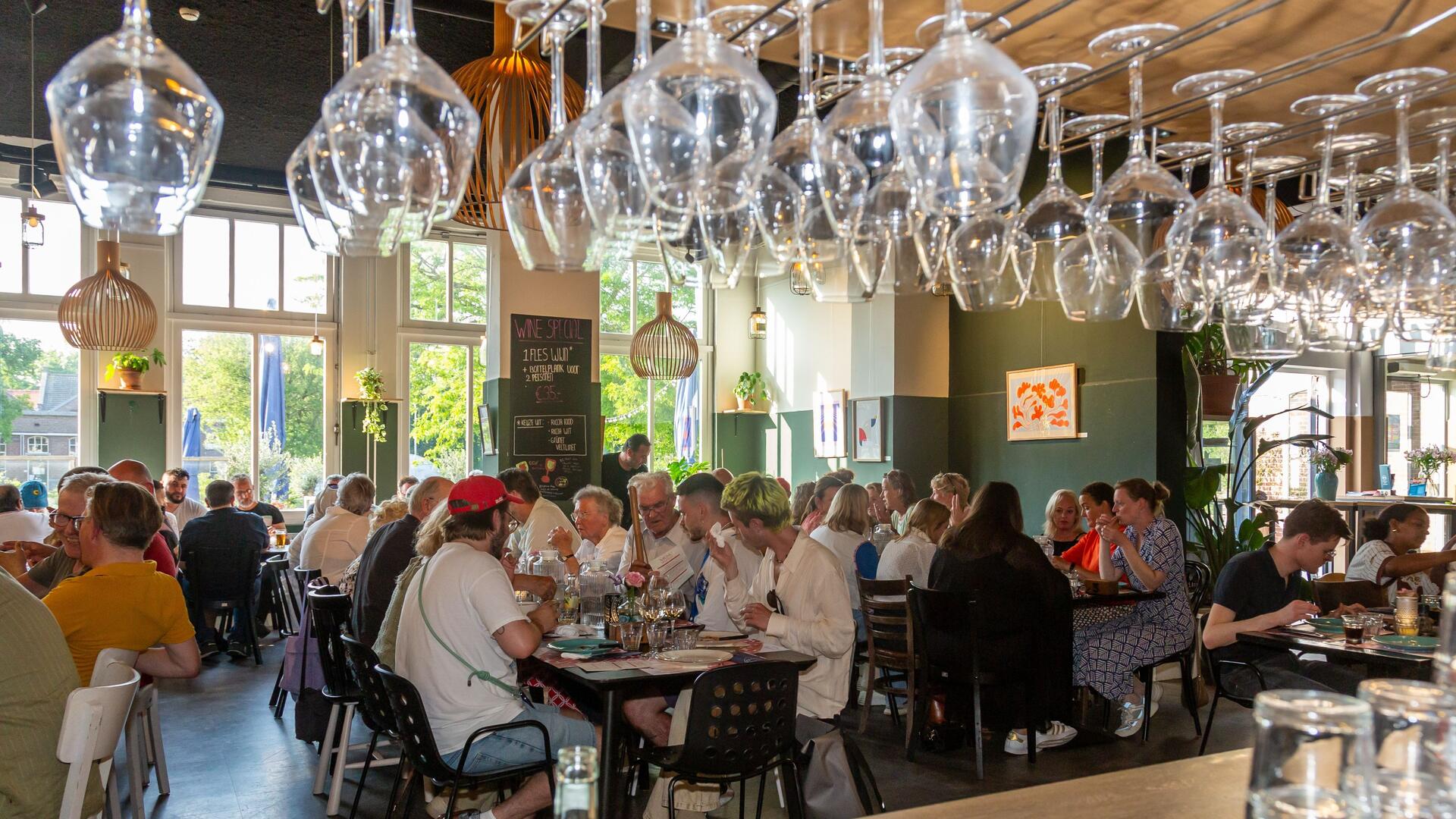 Foto van etende mensen aan lange tafels in De Oude Keuken. Foto door Nico Lute voor Castricum aan Tafel.