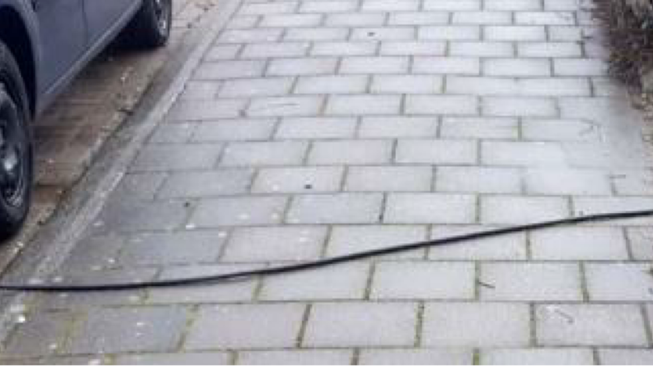 Foto van een losse laadkabel over de stoep